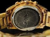 a close up of a gold watch on a black surface