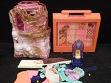 a small doll house with a pink suitcase and other items