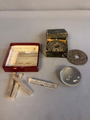 une petite boîte contenant des objets en argent, posée sur une table blanche