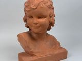 an image of a clay bust of a child on a white background