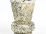 a stone vase that is sitting on top of a table