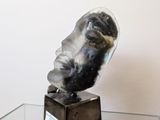 a glass table with a sculpture of a man ' s face on it