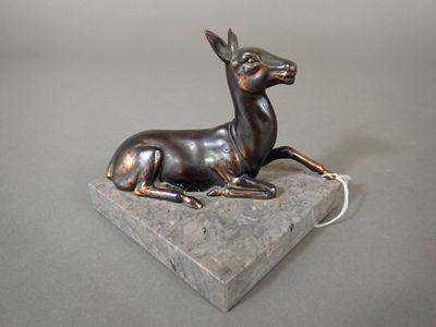 statue of a deer on a stone base on a gray surface