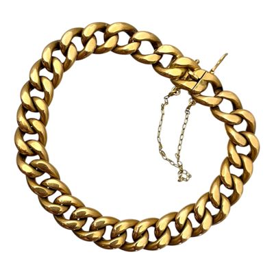 gros plan d'un bracelet en chaîne en or sur fond blanc