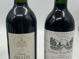 two bottles of red wine sitting next to each other on a table