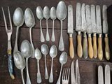many different types of silverware on a wooden table