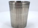 a silver cup that is sitting on a white table