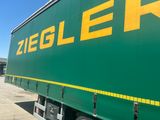 a large green truck with yellow letters on the side