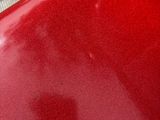 a close up of a red motorcycle parked on the side of the road