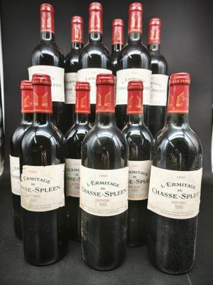 six bouteilles de vin rouge sont alignées sur une table noire