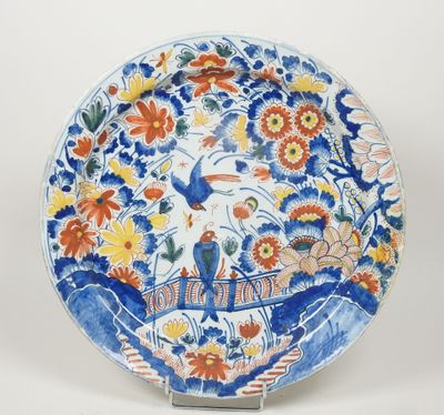 une assiette bleue et blanche ornée d'un oiseau et de fleurs