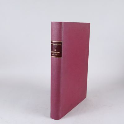 un vieux livre à la couverture rose posé sur une surface blanche