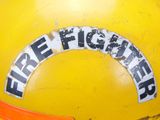 a yellow fire hydrant with a fire fighter sticker on it