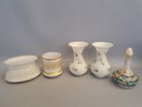 five different vases sitting on a table next to each other