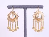 une photo d'une paire de boucles d'oreilles en or posées sur un présentoir
