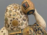 a figurine of a man with a cup on his head