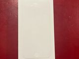 un iPhone 5G blanc posé sur une table rouge