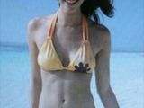 a woman in a yellow bikini standing on the beach