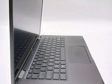 a silver laptop with a black keyboard on a white surface