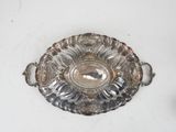 a silver plate with a handle on it on a white surface
