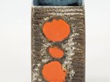 a brown and orange vase with two orange hearts on it