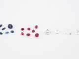 a group of different colored stones arranged in a row on a white surface