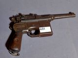 un pistolet posé sur une table, sur laquelle se trouve une étiquette avec un nom