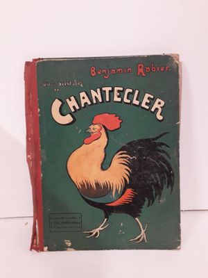 un vieux livre sur lequel figure un coq, posé sur une table