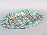 a green and white plate with a design on it