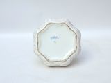 a small white vase with a gold rim on it