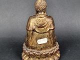 an image of a statue of a buddha sitting on a black surface