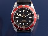 a black and red watch on a blue surface