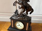 une statue en bronze représentant un homme à cheval sur une horloge