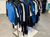 beaucoup de vêtements suspendus à une étagère dans un magasin