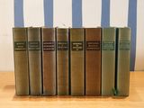 several books are lined up in a row on a wooden table
