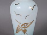 un vase avec un oiseau posé sur une table