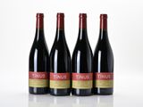 three bottles of red wine sit on a white surface