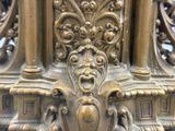 a close up of a gold clock with a face on it