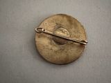 a gold brooch with a pin in the middle of it