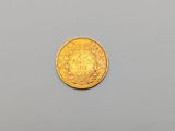 a close up of a gold coin on a gray surface