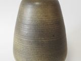 a brown vase that is sitting on a white surface