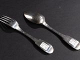 two spoons and a fork sitting on a table