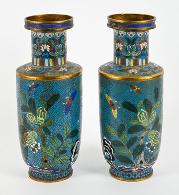 pair of blue vases with birds and flowers on them on a white surface