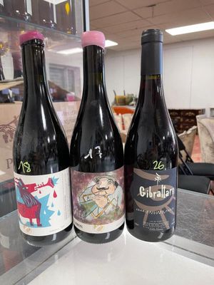 three bottles of wine sitting on a counter in a store