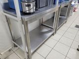 a stainless steel table with a crock pot on top of it