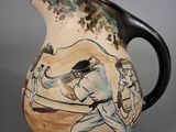 a ceramic pitcher with a painting of a baseball player on it