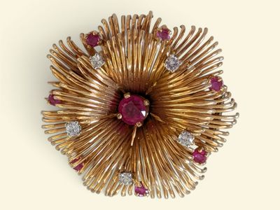 une image représentant une broche en or sertie de rubis et de diamants