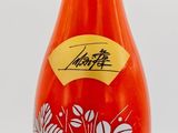 a red bottle with a blue and white design on it