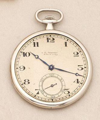 a silver pocket watch with roman numerals on the face