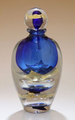 une bouteille en verre bleu ornée d'une feuille d'or
